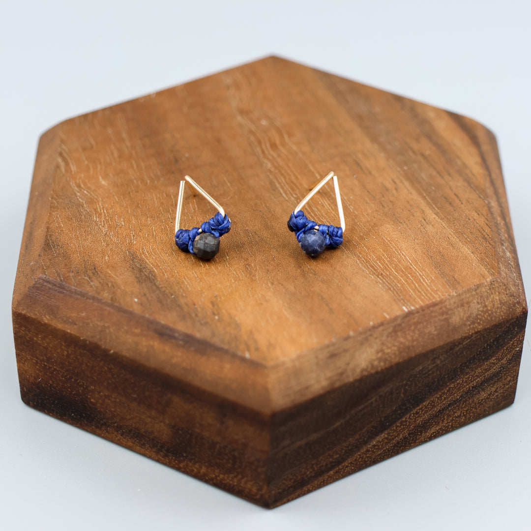 handmade gold filled triangle stud earrings with sapphire beads on a wood display