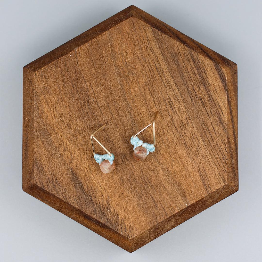 handmade triangle shaped earrings in gold fill with a sunstone bead overhead view