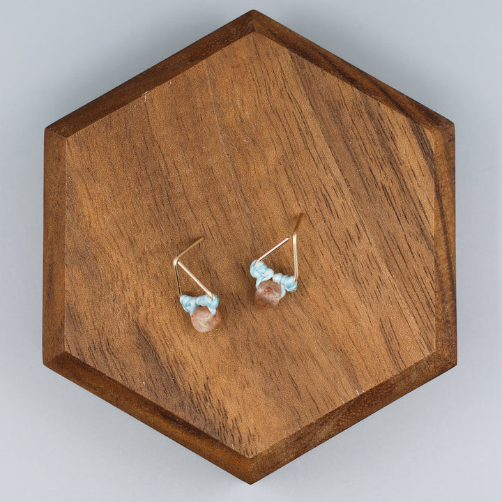 handmade triangle shaped earrings in gold fill with a sunstone bead overhead view