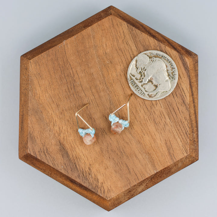 handmade triangle shaped earrings in gold fill with a sunstone bead with a nickel for size comparison