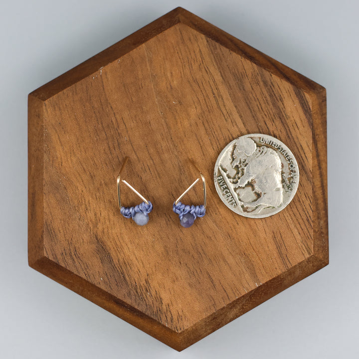 handmade gold filled triangle stud earrings with tanzanite beads  with a nickel for size comparison