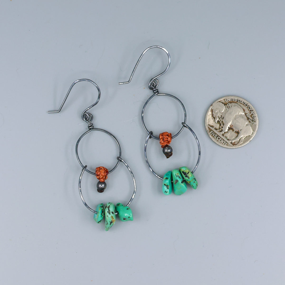 handmade double hoop earrings with turquoise beads and oxidized sterling silver with a nickel for size comparison