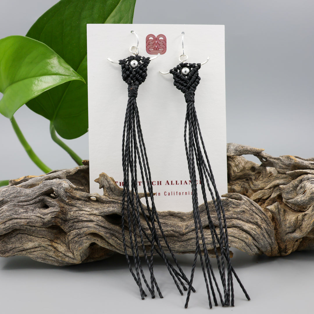 Long, handmade macrame statement earrings in black with sterling silver on a white card