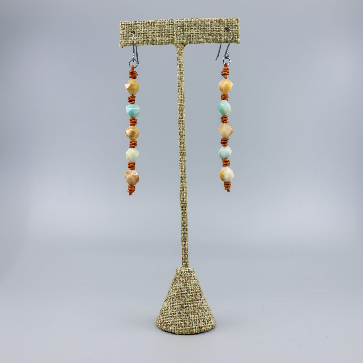 handmade amazonite and leather barrell knot earrings with handmade oxidized sterling silver ear wires on a linen hanger