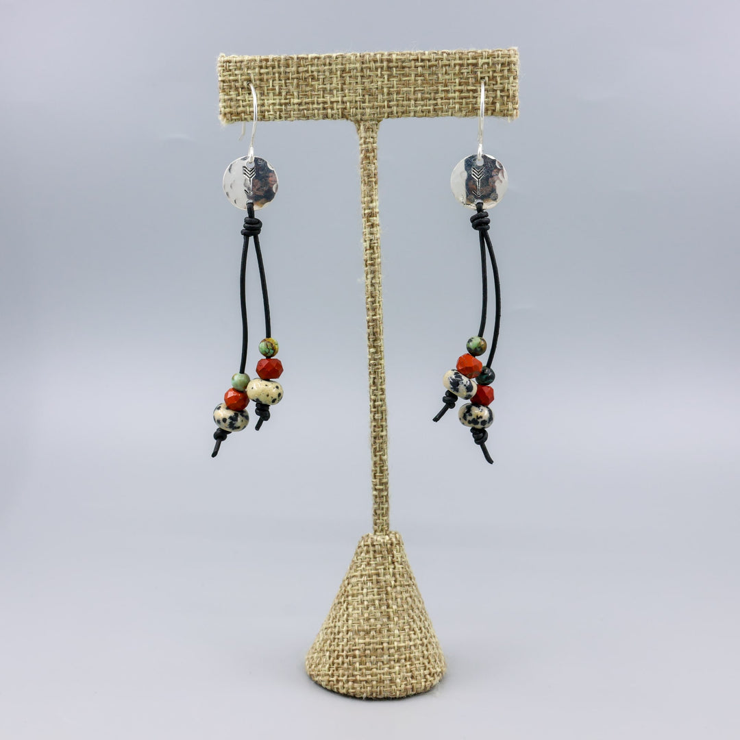 Arrow stamped sterling silver and leather earrings with jasper beads on a linen hanger