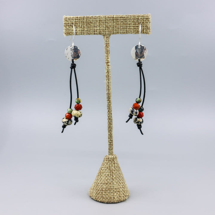 Arrow stamped sterling silver and leather earrings with jasper beads on a linen hanger