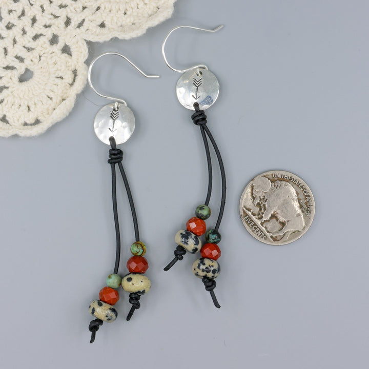 Arrow stamped sterling silver and leather earrings with jasper beads with a nickel for size comparison