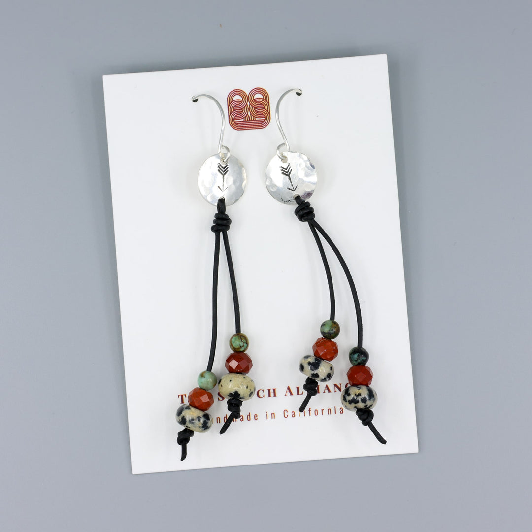 Arrow stamped sterling silver and leather earrings with jasper beads on a white card