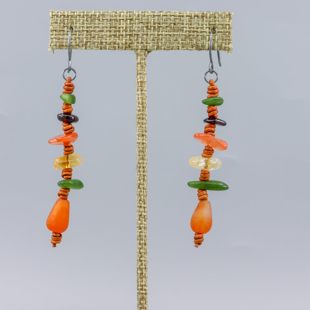 handmade agate, jade, citrine, and garnet leather dangle earrings with oxidized sterling silver ear wires shown on a linen display hanger