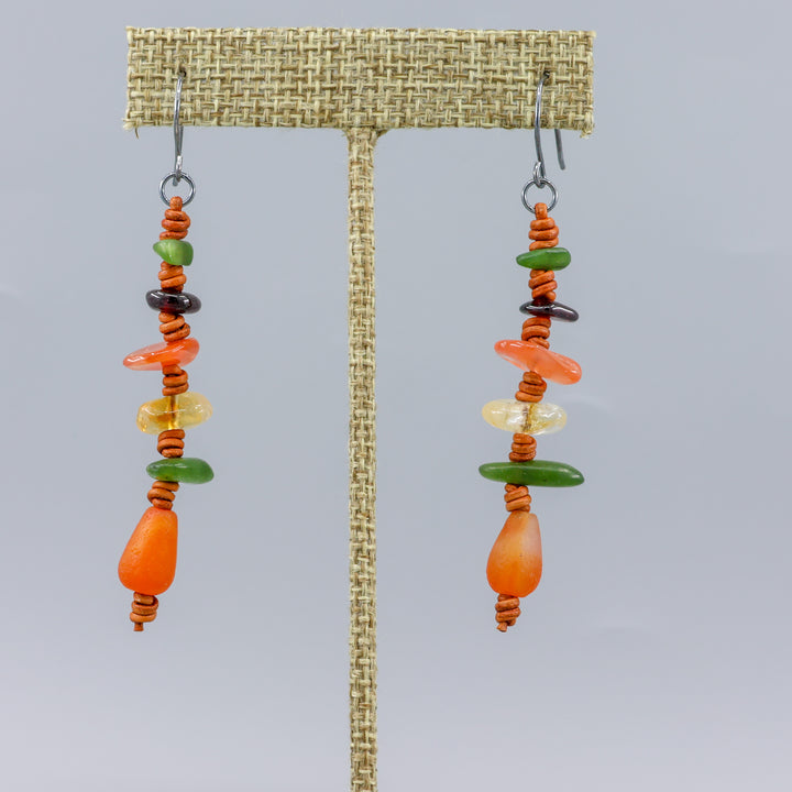 handmade agate, jade, citrine, and garnet leather dangle earrings with oxidized sterling silver ear wires shown on a linen display hanger