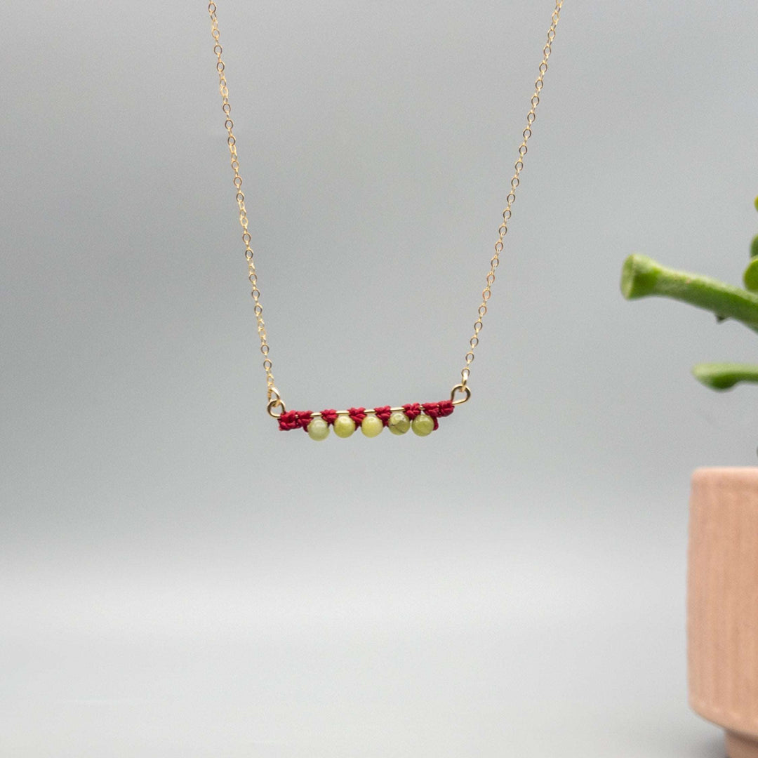 14k gold filled bar necklace with peridot beads and macrame