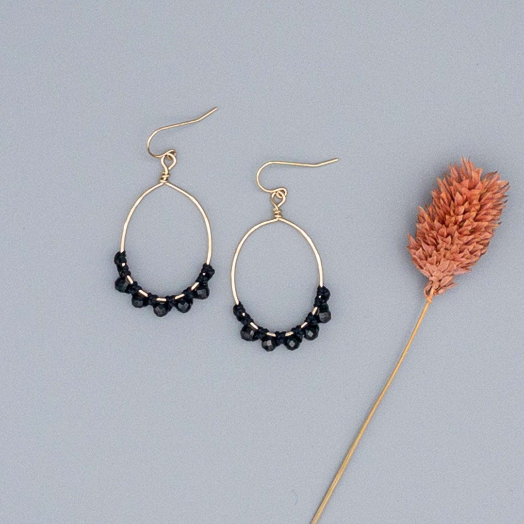 black spinel gold filled hoops on a gray background