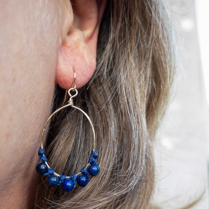 model wearing blue lapis hoop earrings 14k gold filled oval shape