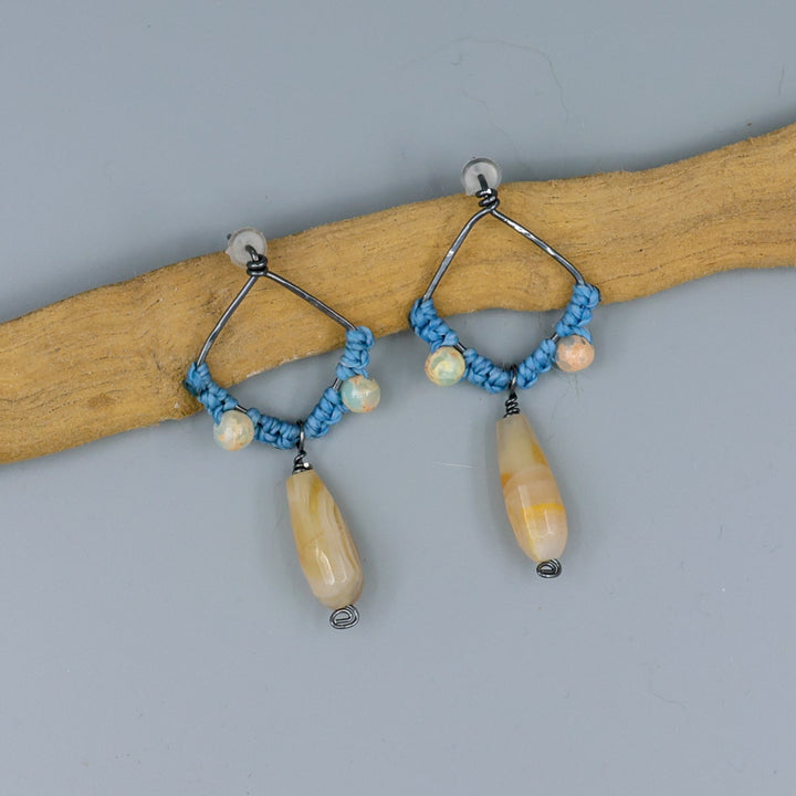 handmade macrame earrings with botswana agate and aqua terra jasper beads oxidized sterling silver on a gray background