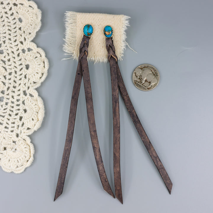 handmade turquoise earrings with distressed black leather fringe with a nickel for size comaparison
