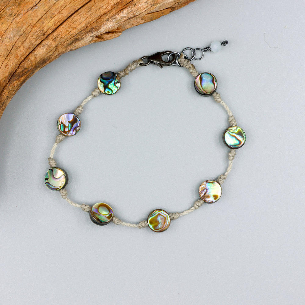 handmade abalone bracelet with sterling silver clasp on a gray background