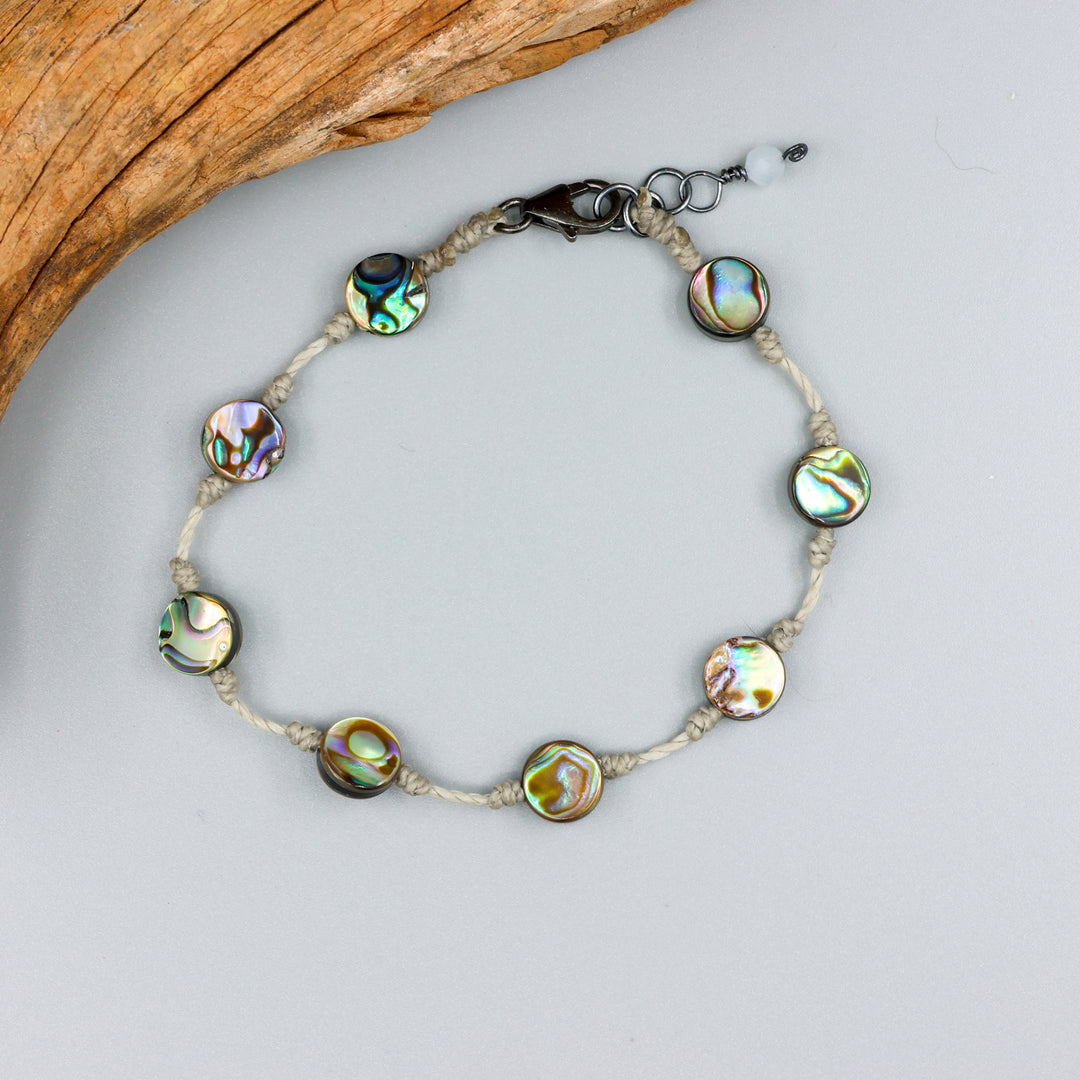 handmade abalone bracelet with sterling silver clasp on a gray background