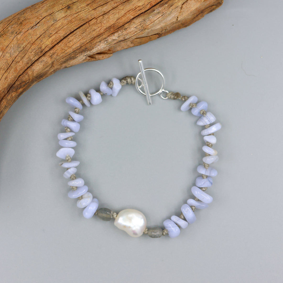 handknotted blue lace agate and freshwater pearl bracelet with a sterling silver clasp on a gray background
