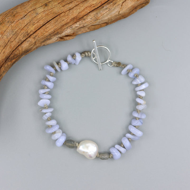 handknotted blue lace agate and freshwater pearl bracelet with a sterling silver clasp on a gray background