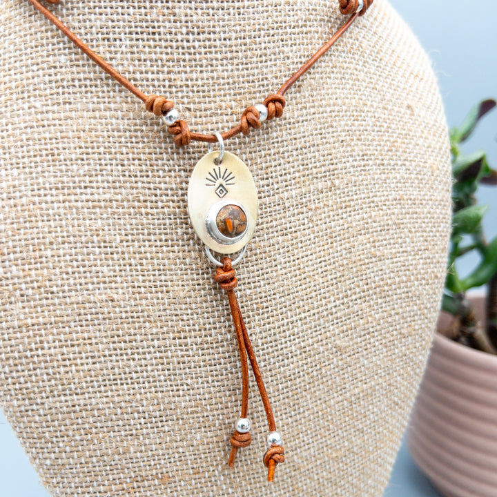 detail view of orange copper turquoise set in a brass pendant with sterling silver beads