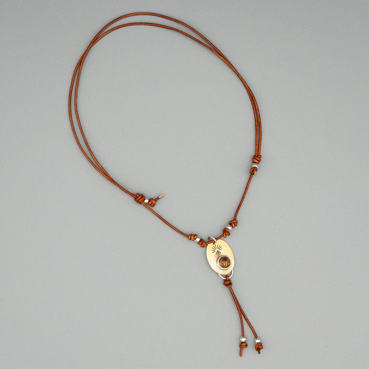 orange copper turquoise set in a brass pendant with sterling silver beads on a gray background