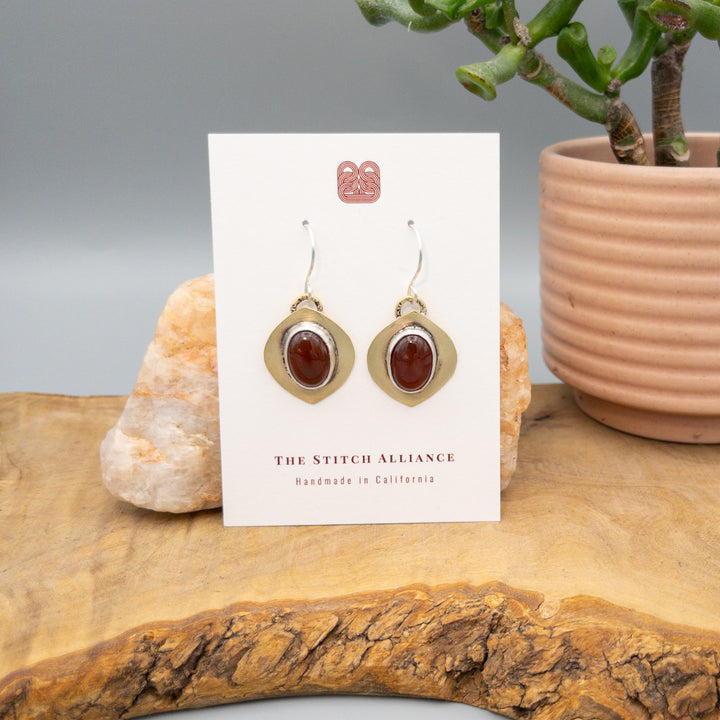 Brass, sterling silver, and carnelian handmade earrings on a white card