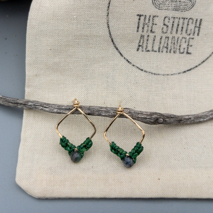 Cancer emerald gold filled macrame earrings on a muslin bag
