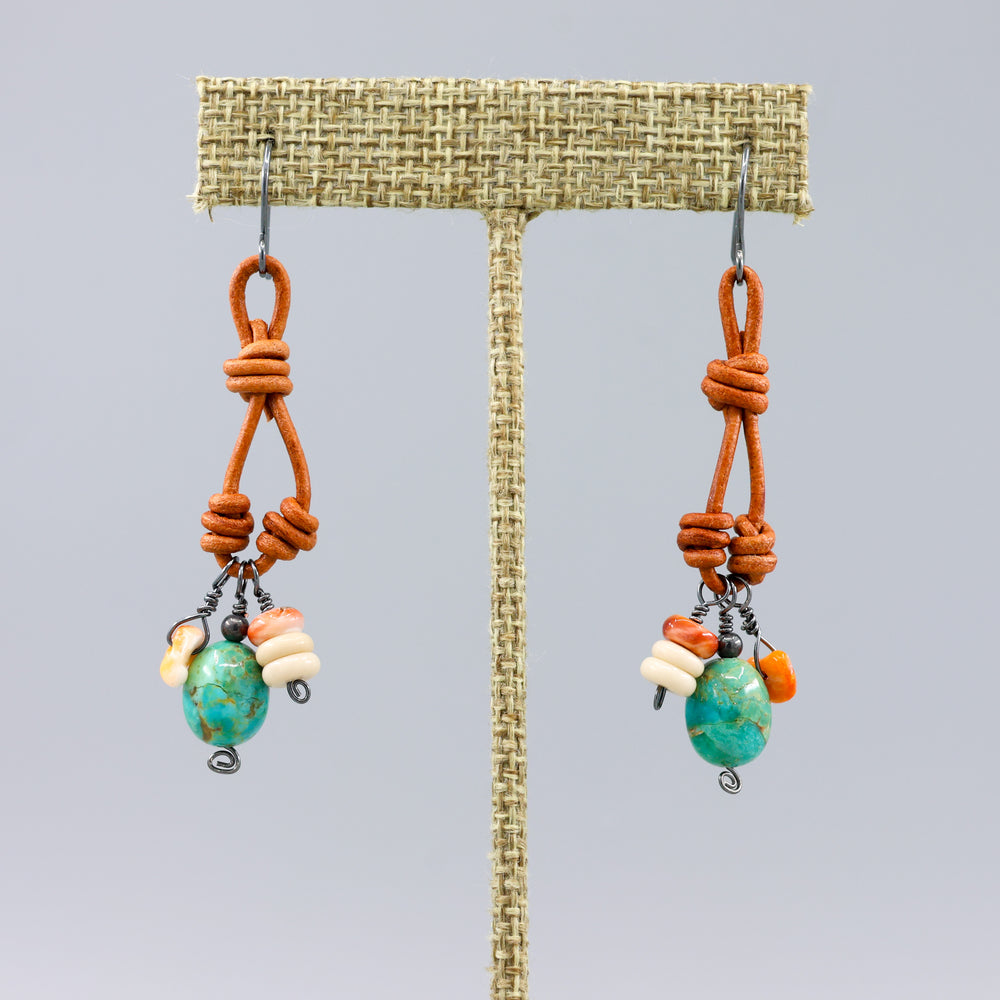 handmade turquoise, spiny oyster, leather, oxidized sterling silver charm earrings on a linen hanger