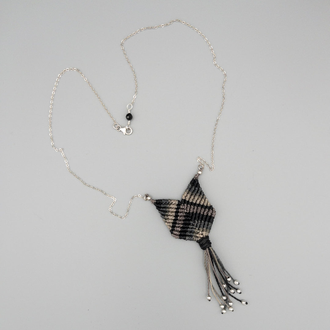 black and gray macrame necklace with sterling silver chain on gray background