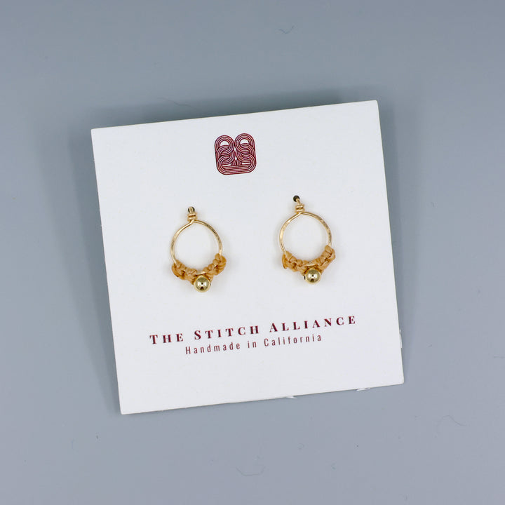 handmade gold macrame stud earrings on a white card