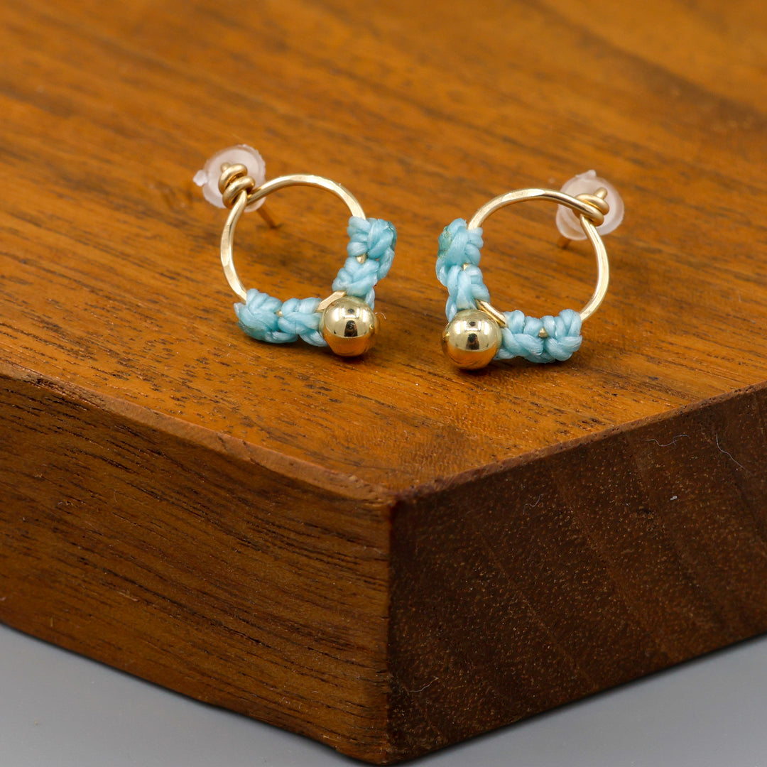 small, handmade gold macrame earrings in blue