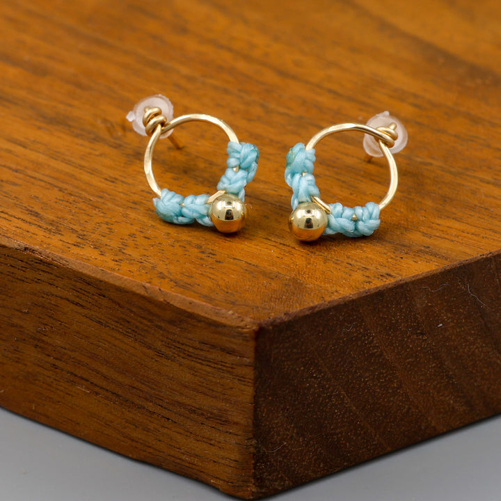 small, handmade gold macrame earrings in blue