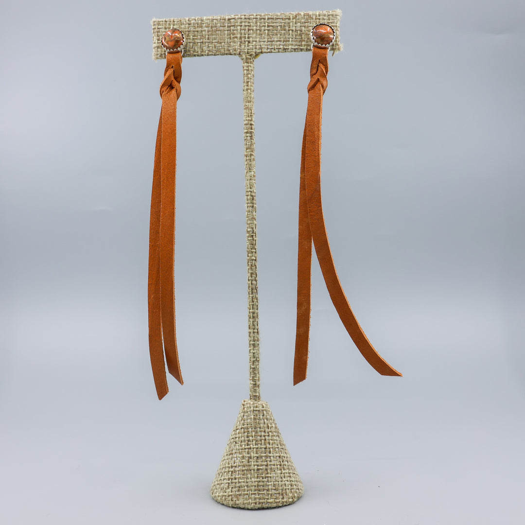 orange copper turquoise earrings with leather fringe on a linen hanger