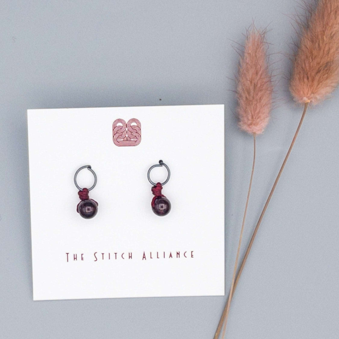 circle post style earrings handcrafted with gunmetal sterling silver and a 6mm garnet bead
