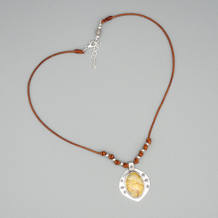 Crazy lace agate, sterling silver, leather necklace on a gray background