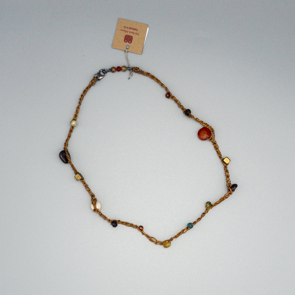 garnet and carnelian fall gemstone crochet necklace on a gray background