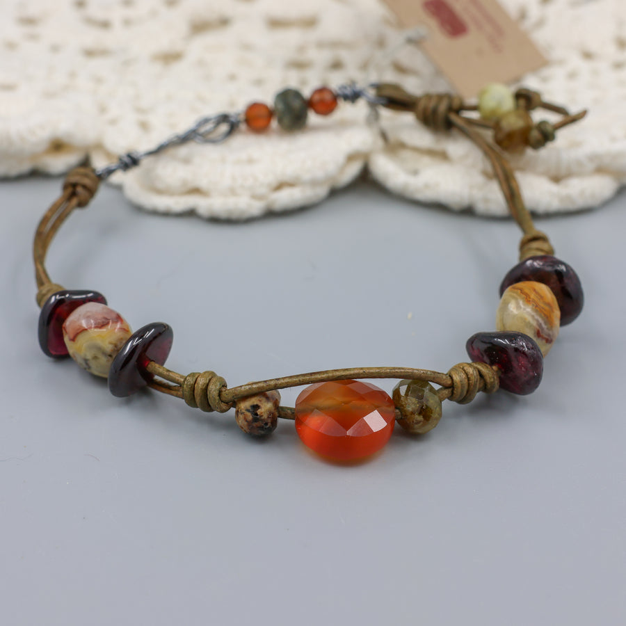 handmade leather and gemstone bracelt with garnet, carnelian, crazy lace agate, and hessonite with oxidized sterling silver clasp