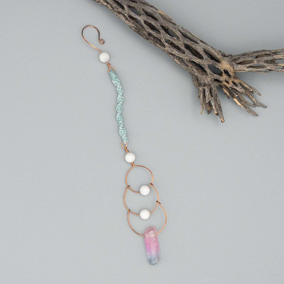 Copper, moonstone, and crystal window hanger sun catcher on a gray background