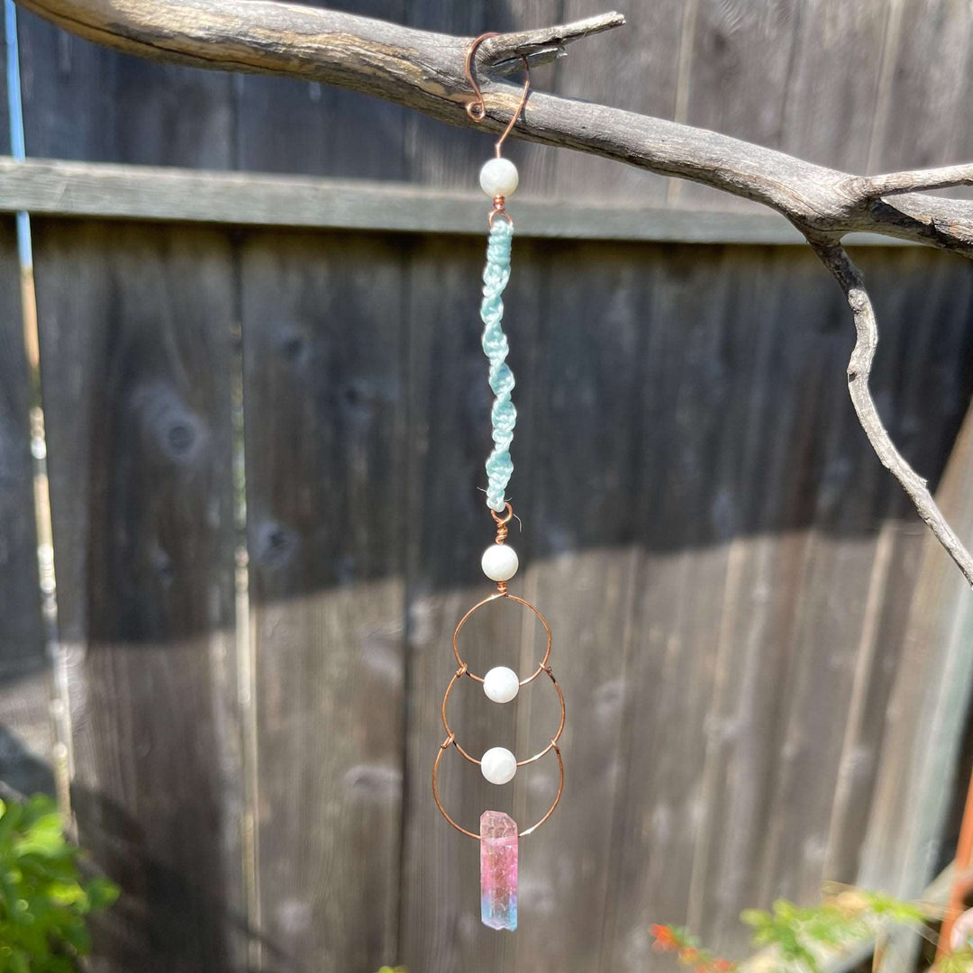 Copper, moonstone, and crystal window hanger sun catcher photographed outdoors