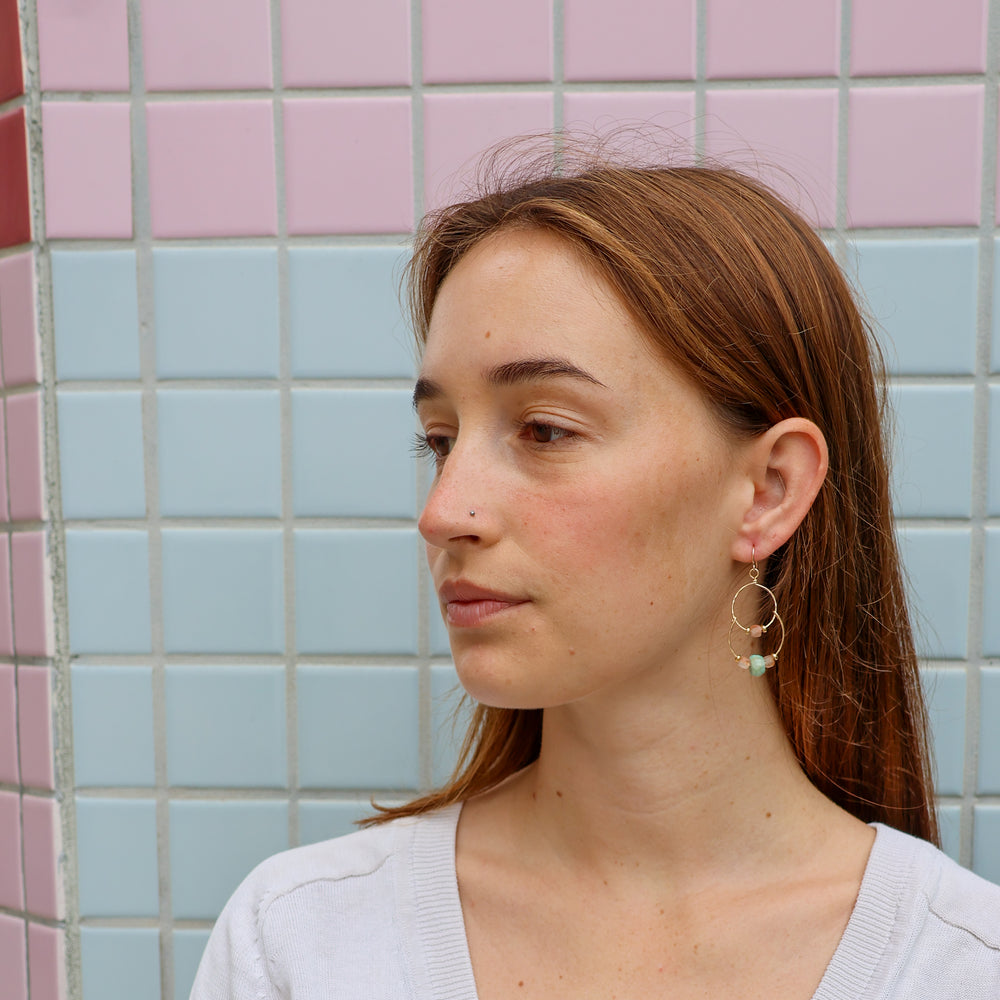 handmade gold double hoop earrings with sunstone and amazonite beads worn on model