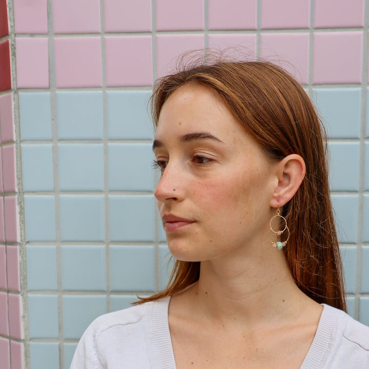 handmade gold double hoop earrings with sunstone and amazonite beads worn on model