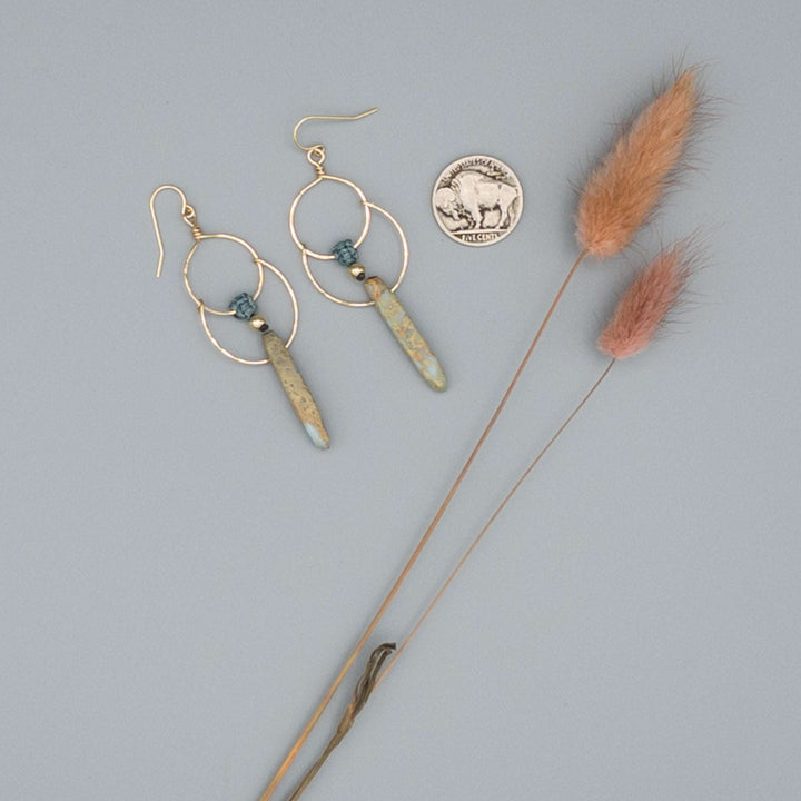 14k gold filled double hoop earrings with an aqua terra jasper bead on a gray background with a buffalo nickle 
