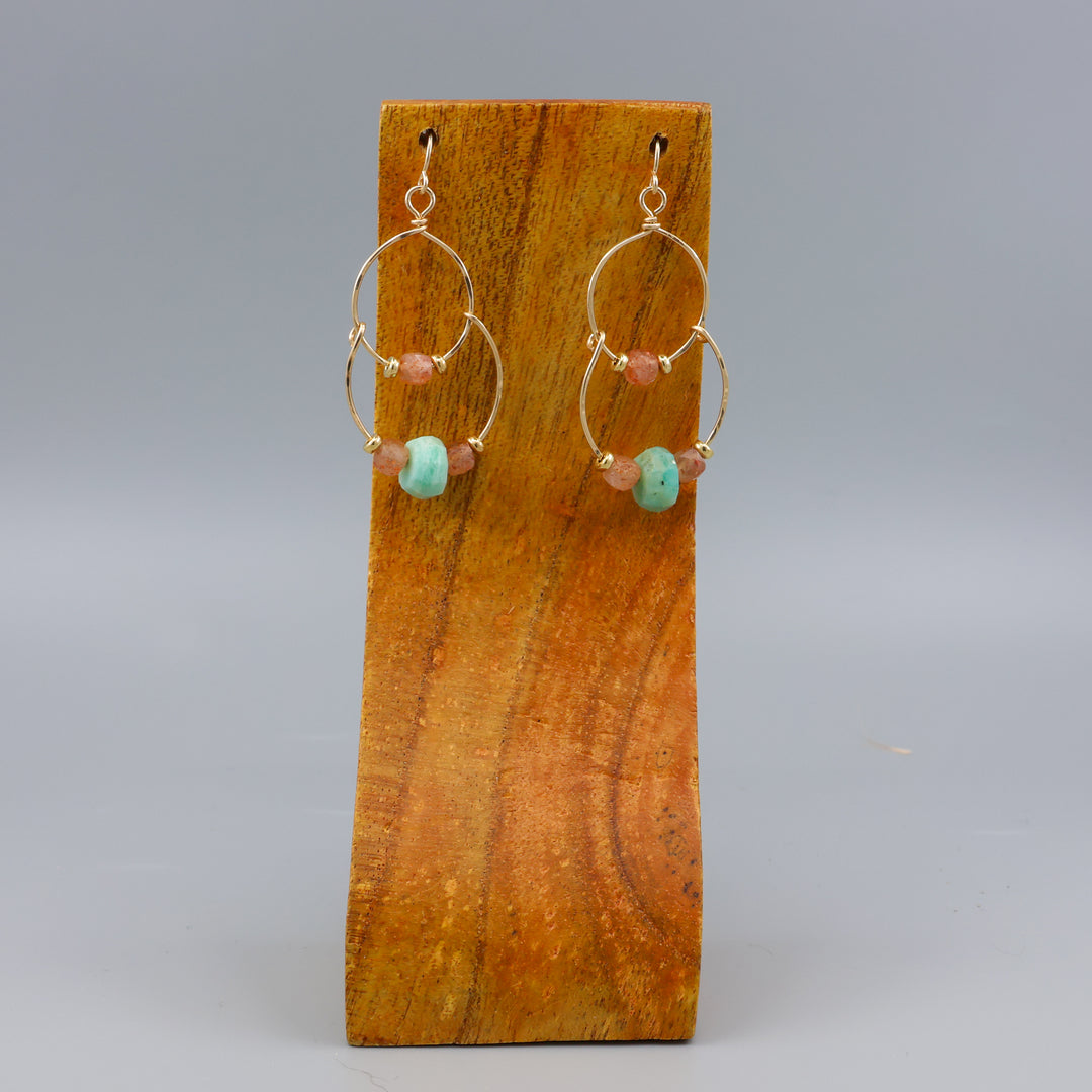handmade gold fill double hoop earrings with amazonite and sunstone beads on a wood display