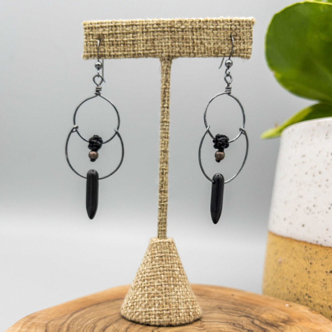 Hand-formed double hoop earrings made with oxidized sterling silver. Black howlite spike shaped bead and macrame pearl. 