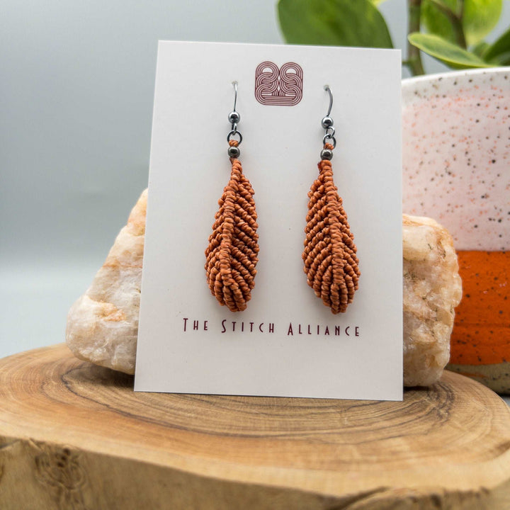 Earthy terracotta macrame feather earrings with oxidized sterling silver ear wires on white background