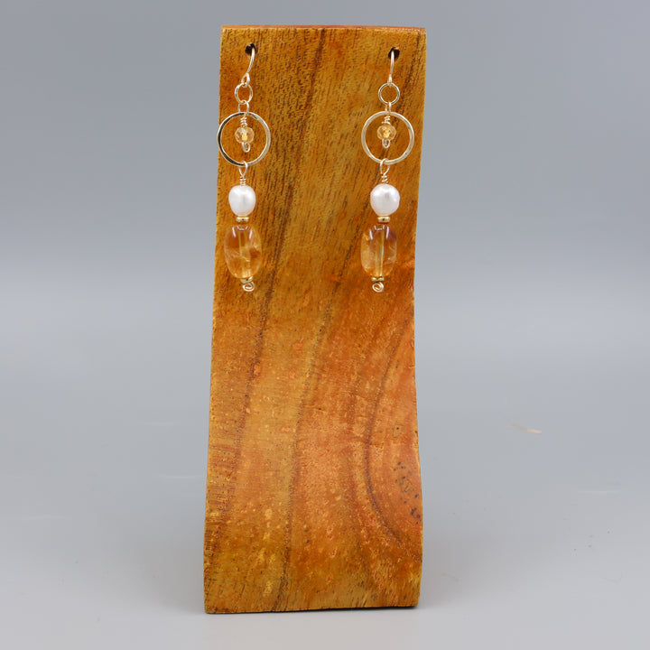 handmade gold fill earrings with citrine and freshwater pearl beads on a wood display