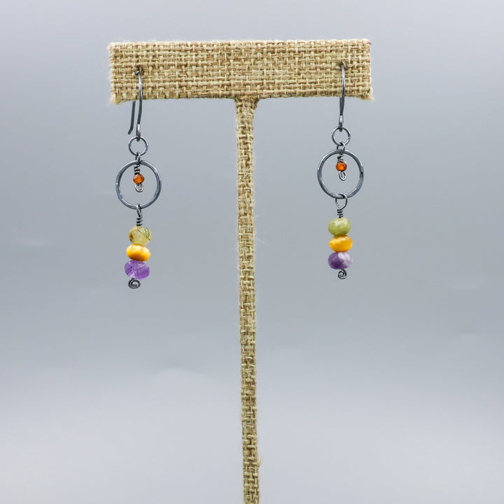 handmade oxidized sterling silver, amethyst, golden tigers eye, green garnet, and hessonite dangle earrings on a linen hanger