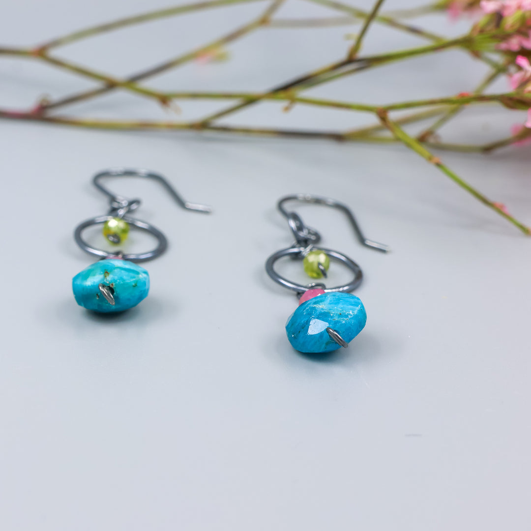 detail view of handmade gemstone and oxidized sterling silver earrings with apatite, pink tourmaline, and peridot