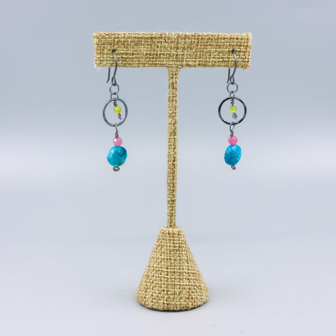 handmade gemstone and oxidized sterling silver earrings with apatite, pink tourmaline, and peridot on a linen hanger
