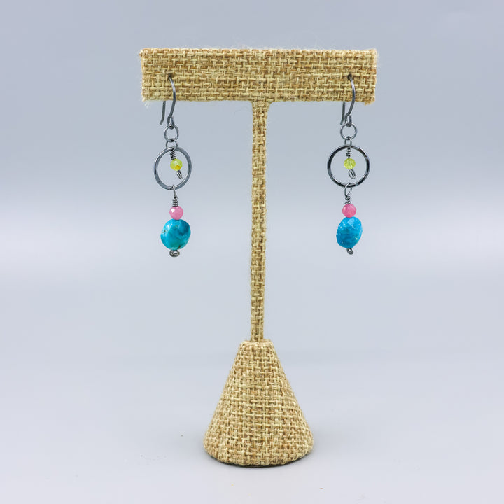 handmade gemstone and oxidized sterling silver earrings with apatite, pink tourmaline, and peridot on a linen hanger